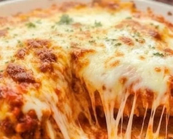 Plate of Chicken Parmesan with marinara sauce and melted cheese