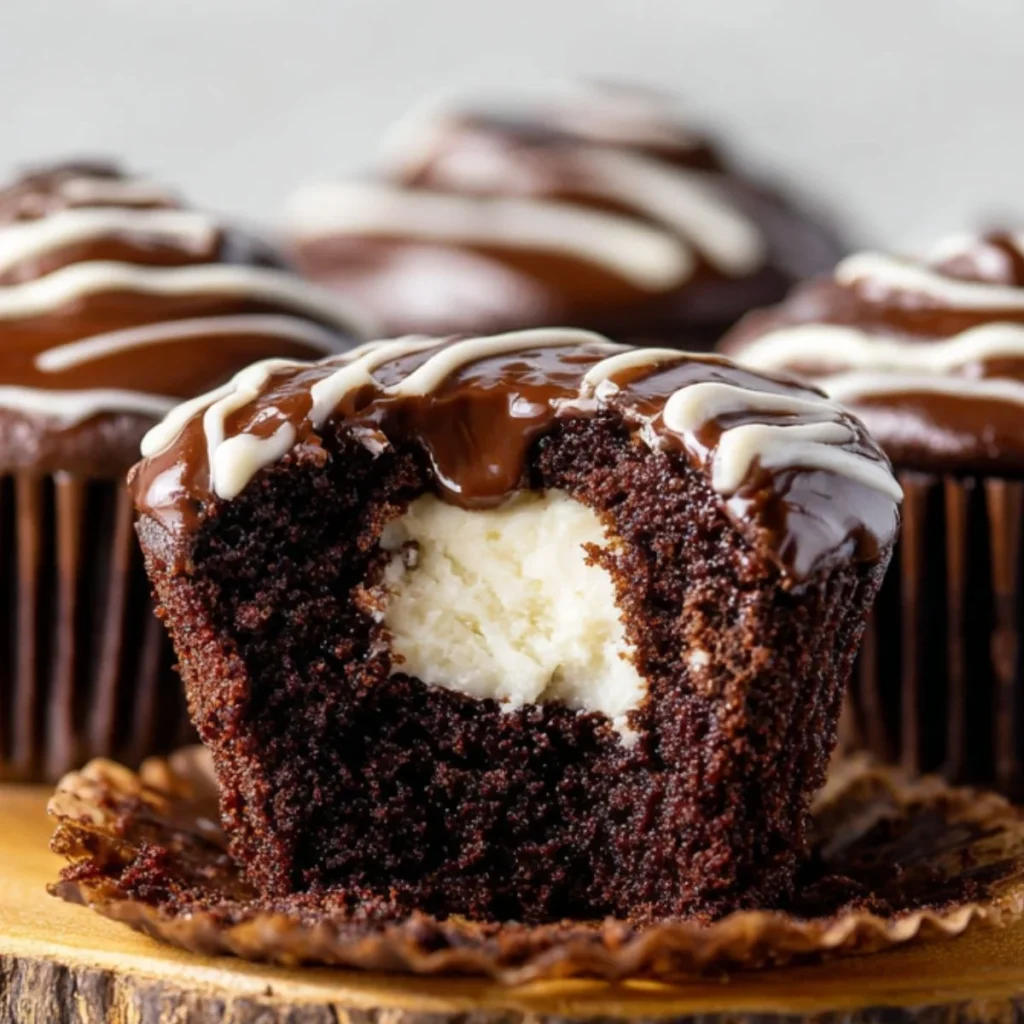 Cream-filled chocolate cupcakes on a decorative plate.