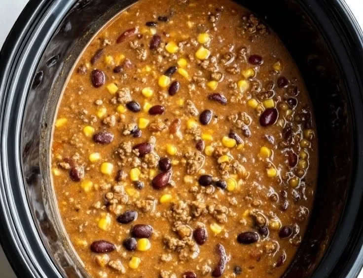 Bowl of creamy beef taco soup topped with cheese and cilantro