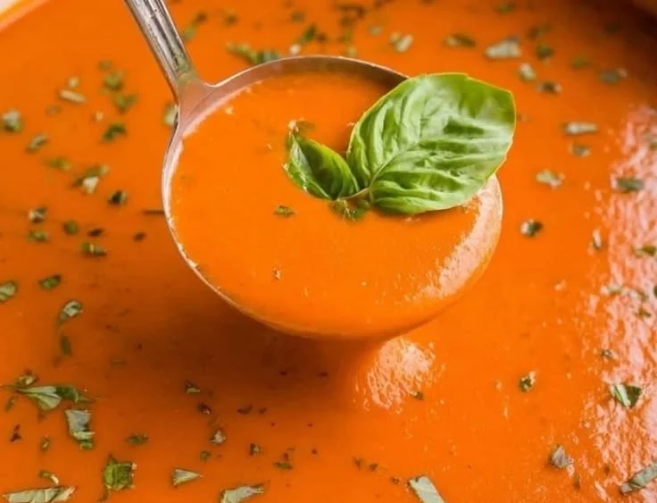 Delicious creamy tomato bisque soup served in a bowl with fresh herbs