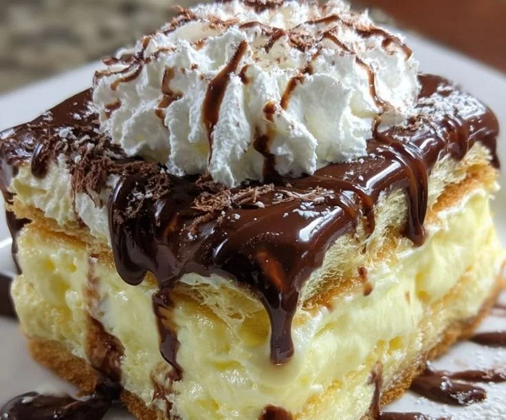 Delicious easy eclair cake dessert layered with cream and chocolate icing.