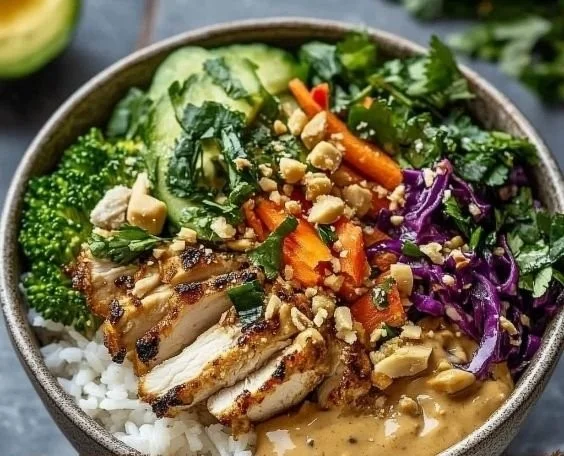 High-protein Thai Peanut Chicken bowl with vibrant vegetables and creamy sauce.