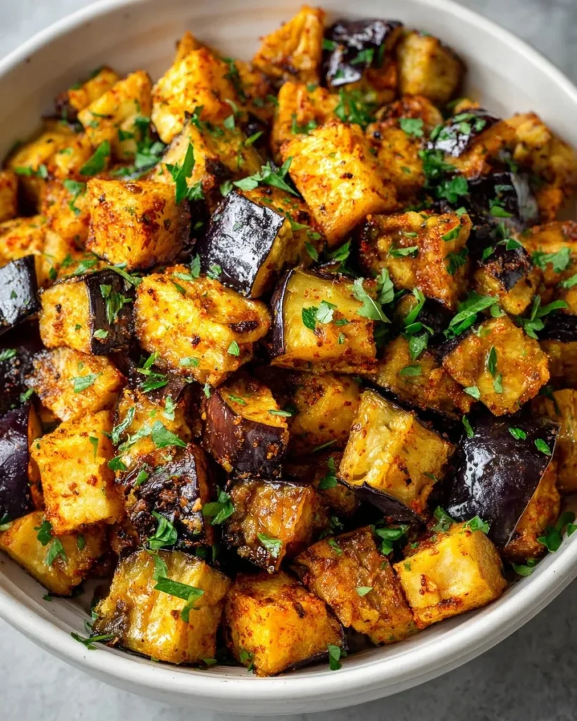 Low calorie air fryer eggplant dish on a plate, garnished with herbs.