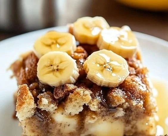 Delicious banana bread pudding served with cream and fresh bananas