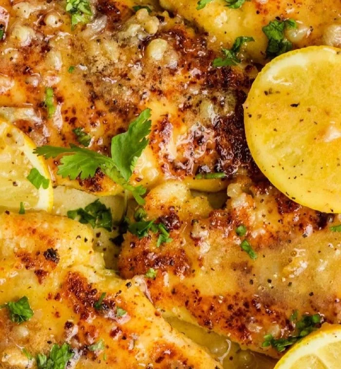 30-Minute lemon chicken served with fresh herbs and lemon wedges