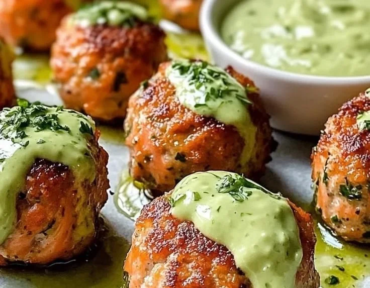 Baked salmon meatballs with creamy avocado sauce on a plate