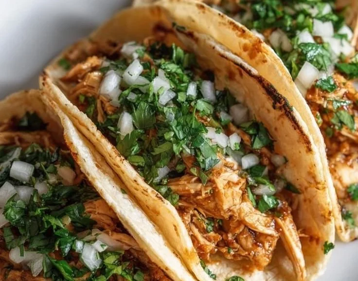 Plate of flavorful chicken tacos with fresh toppings and garnishes