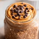 Bowl of chocolate peanut butter overnight oats topped with banana and nuts