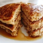 Fluffy oatmeal pancakes topped with fresh berries and syrup