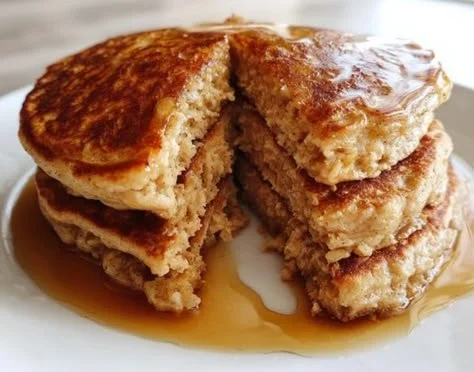 Fluffy oatmeal pancakes topped with fresh berries and syrup