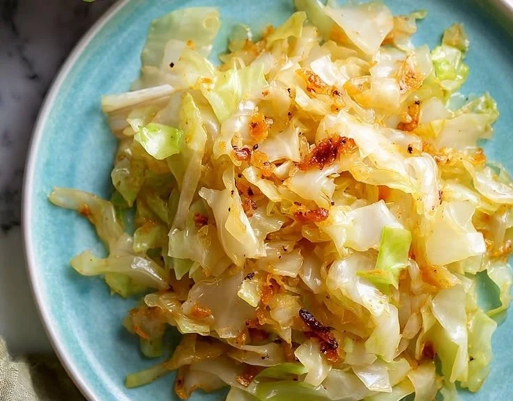 Plate of Garlic Sautéed Cabbage garnished with herbs