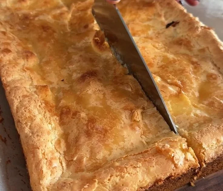Delicious slice of Gooey Butter Cake topped with powdered sugar.