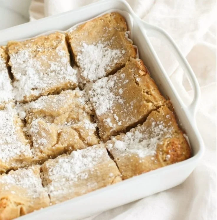 Slice of delicious Gooey Butter Cake topped with powdered sugar