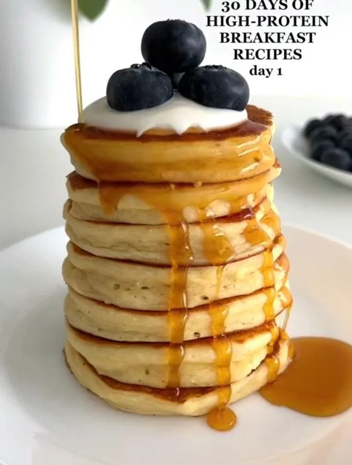 Fluffy high-protein pancakes stacked with syrup and berries