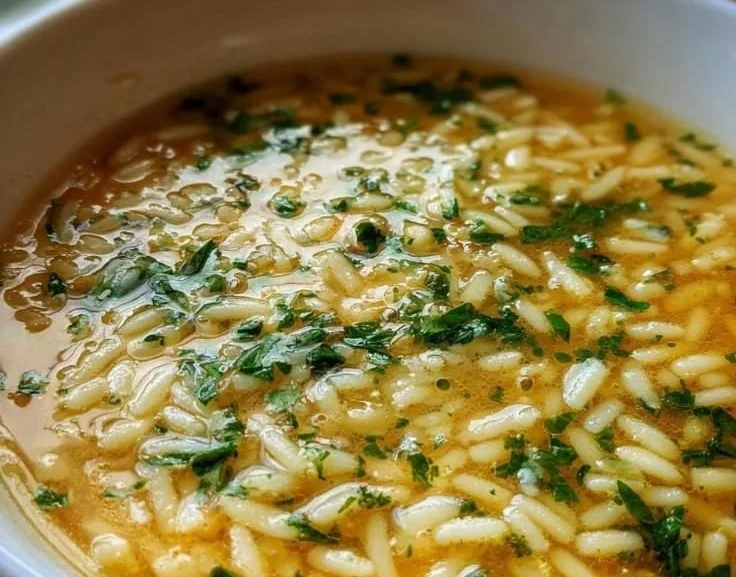 Bowl of Italian Penicillin Soup garnished with herbs and vegetables.