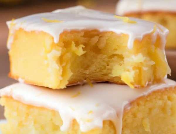 Delicious lemon brownies with a tangy lemon glaze on a white plate