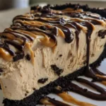 No-bake peanut butter pie topped with chocolate drizzle and peanuts