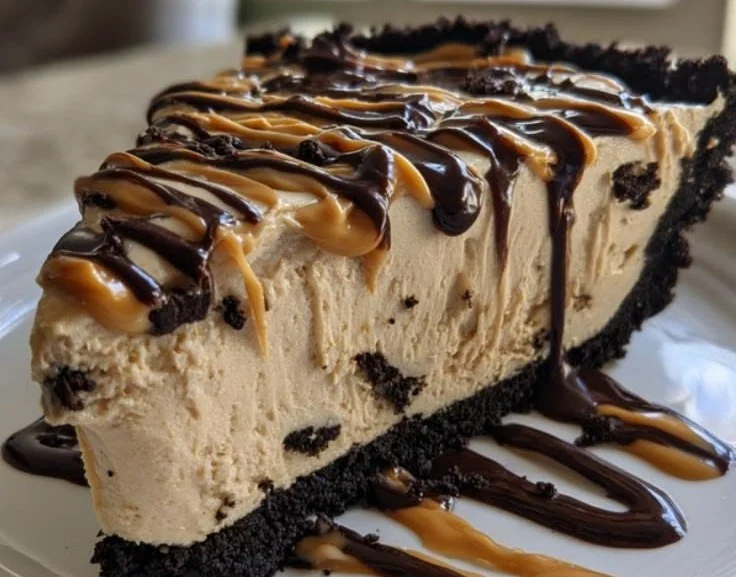 No-bake peanut butter pie topped with chocolate drizzle and peanuts
