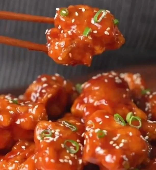 Delicious sesame chicken served with rice and vegetables.