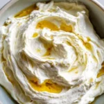 A bowl of creamy whipped feta dip with herbs and pita chips