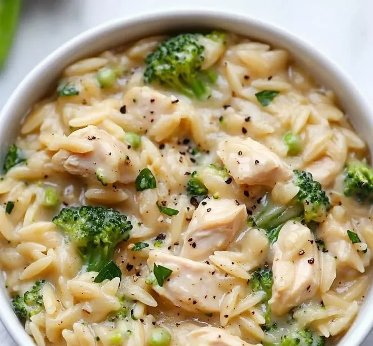 Delicious chicken and broccoli orzo dish garnished with herbs