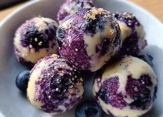 Blueberry cheesecake protein bites on a plate, healthy dessert option.