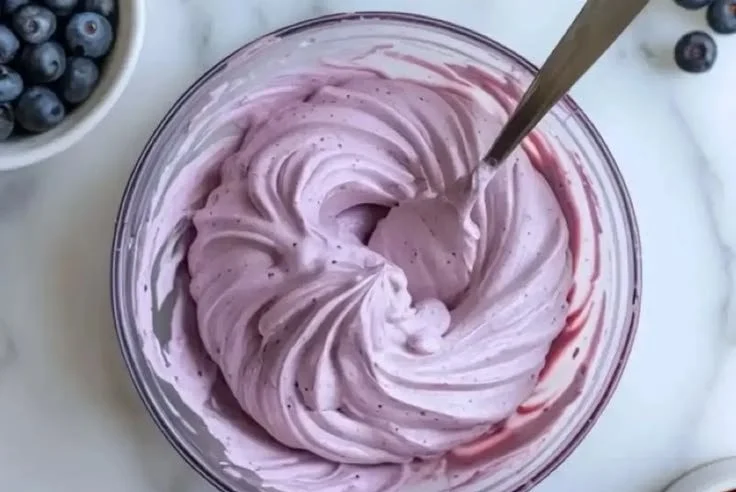 Blueberry cream cheese frosting spread on a cake