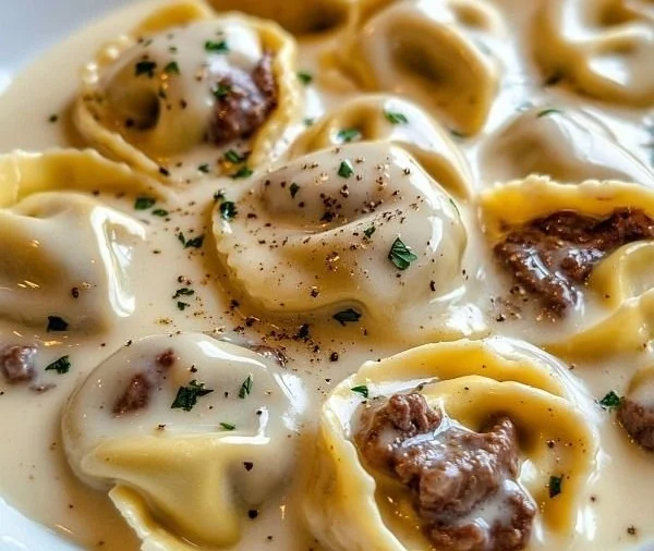 Bowl of cheesesteak tortellini in creamy provolone sauce