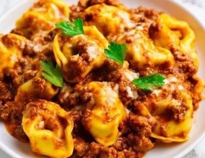 Cheesy beef tortellini enchilada casserole topped with melted cheese