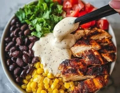 Chipotle Chicken Bowl with black beans and corn topped with a creamy sauce
