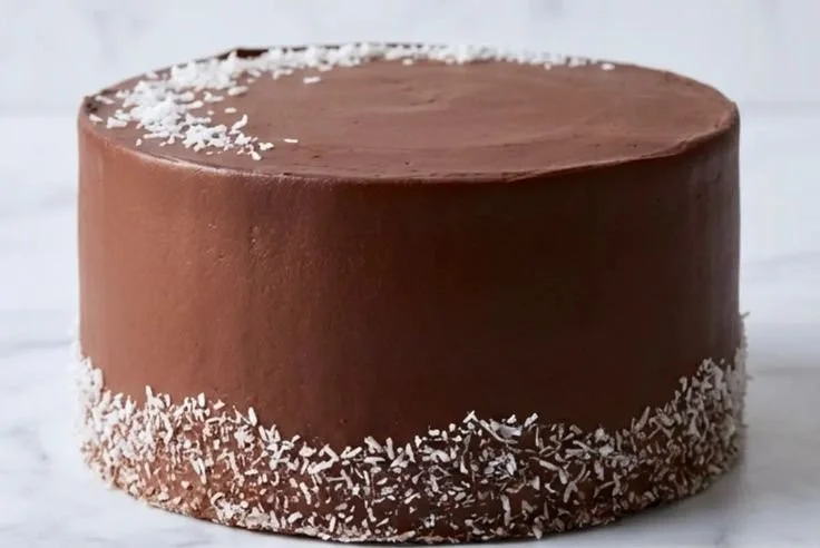 Deliciously moist Chocolate Coconut Cake topped with rich chocolate ganache.