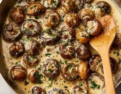 Creamy garlic parmesan sautéed mushrooms in a skillet