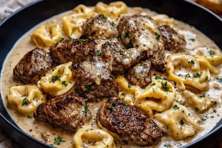 Delicious garlic steak pasta dish topped with fresh herbs and parmesan