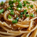 Plate of Garlic Sesame Noodles garnished with sesame seeds and green onions