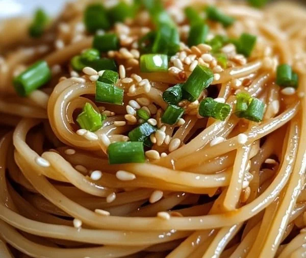 Plate of Garlic Sesame Noodles garnished with sesame seeds and green onions