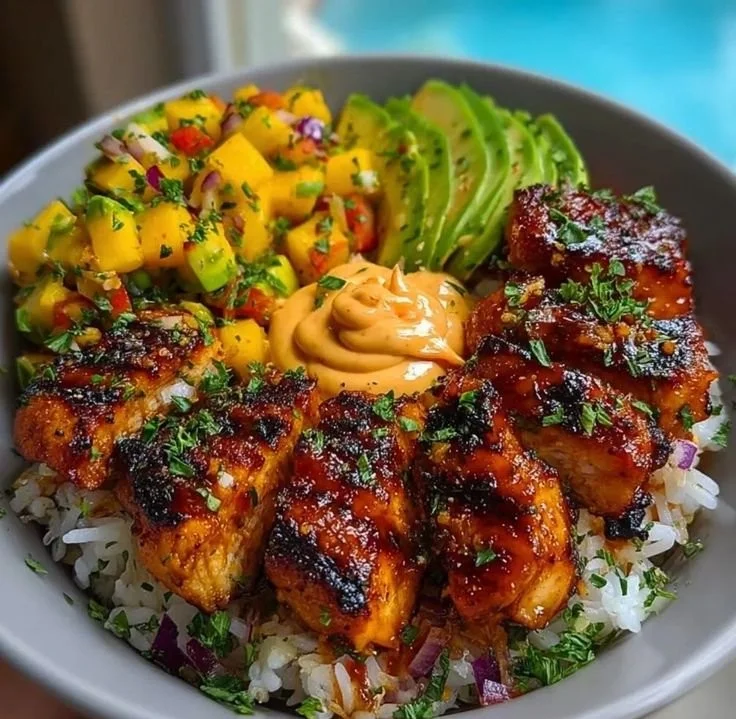 Grilled maple sriracha chicken bites with coconut rice and mango avocado salsa bowl