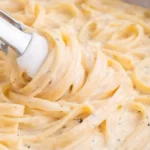 A creamy bowl of homemade Alfredo sauce ready for pasta dishes.