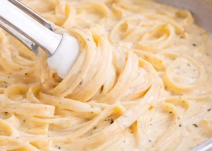 A creamy bowl of homemade Alfredo sauce ready for pasta dishes.