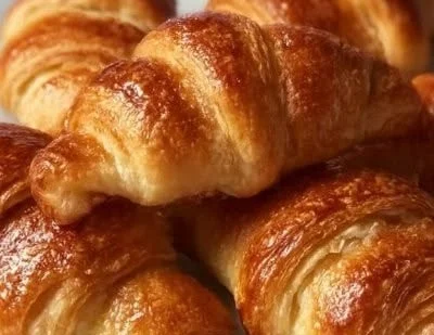 Freshly baked homemade crescent rolls on a wooden table