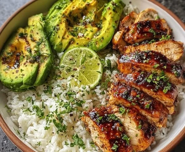 Honey Lime Chicken served in a bowl with avocado rice and fresh garnishes