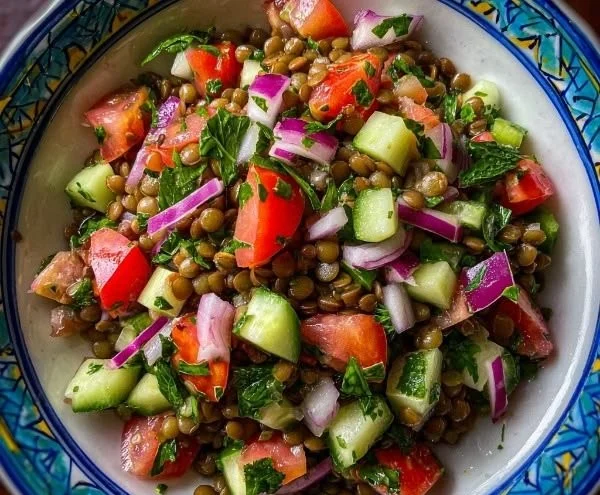 Colorful lentil salad with fresh vegetables and herbs in a bowl