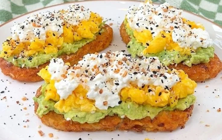 Delicious plate of Loaded Hashbrowns topped with cheese, bacon, and green onions.