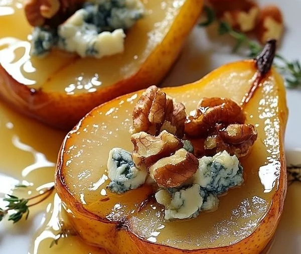 Roasted pears topped with blue cheese, walnuts, and honey, served as a gourmet dessert.