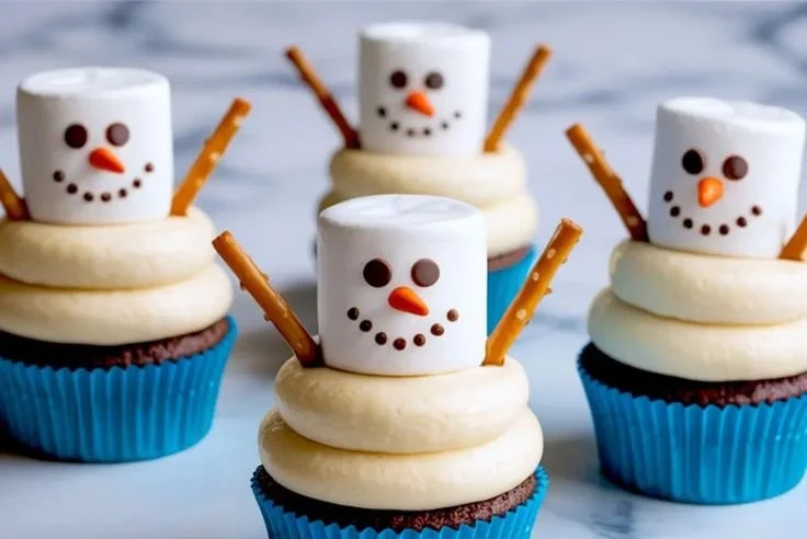 Delicious Snowman Cupcakes decorated with frosting and edible accessories.