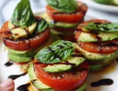 Delicious tomato avocado stacks served on a plate with vibrant colors.