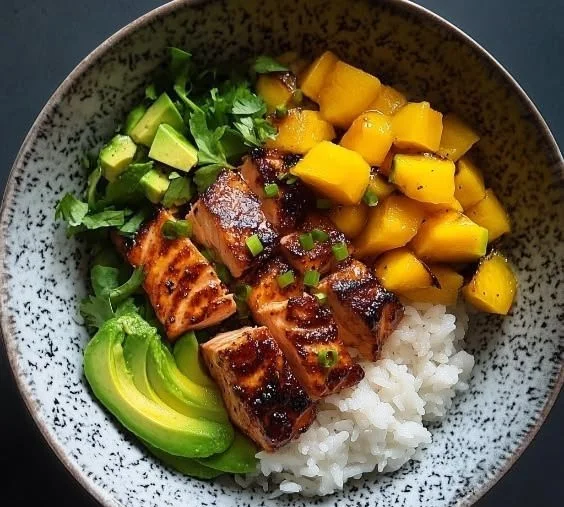 BBQ salmon bowl topped with mango avocado salsa on a plate