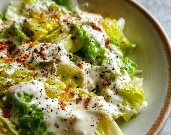 Creamy Greek yogurt Caesar dressing served in a bowl with fresh greens