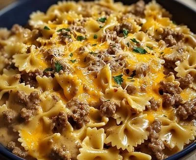 Creamy beef and bowtie pasta dish served in a bowl with fresh herbs.