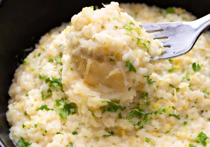 Creamy Parmesan Rice in a bowl, garnished with fresh herbs and cheese.