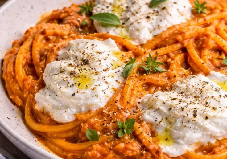 Creamy red pepper pasta topped with burrata cheese and fresh basil.